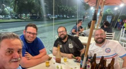 Daniel (de camisa azul) e seus colegas em quiosque na Barra da Tijuca momentos antes do ataque