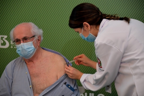 O mdico Almir Ferreira de Andrade, de 79 anos, recebe a vacina CoronaVac contra a Covid-19 no Hospital das Clnicas, em So Paulo, neste domingo (17)  Foto: Nelson Almeida/AFP